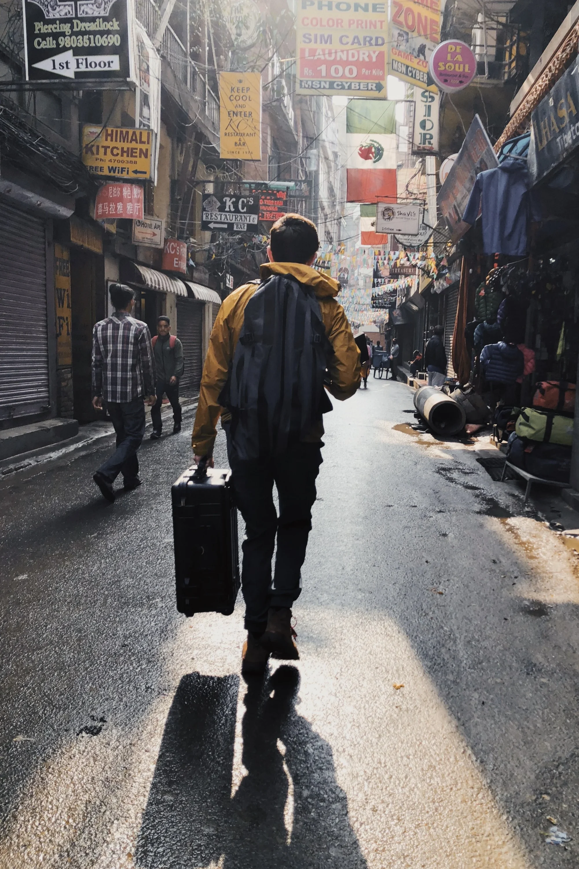 A man walking down a city street, holding a suitcase