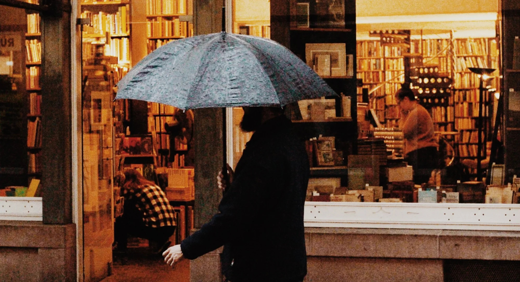 A person walking in front of a bookstore