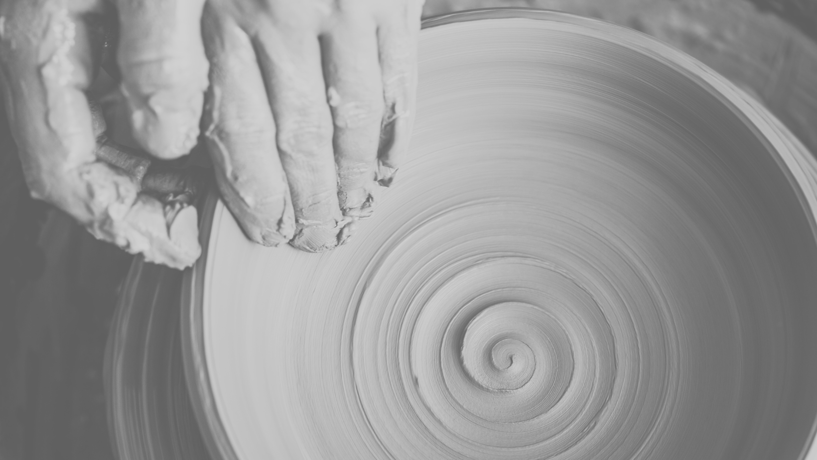 Hands shaping clay into a bowl